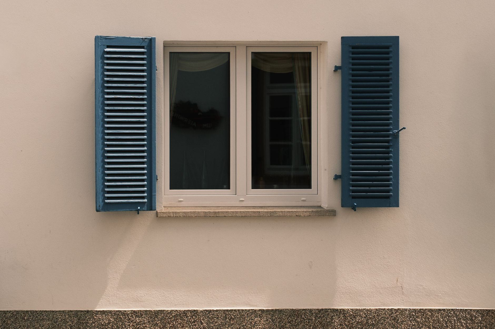 A classic window with blue shutters on an older building